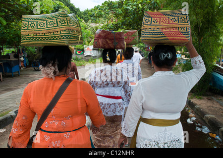 Frauen, die Körbe mit Tempelopfern zu einem Festival in Padang Bai auf bali Stockfoto