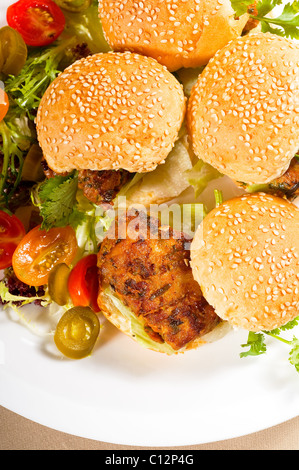 vier frische und köstliche Mini-Chicken Burger auf einem Teller, Nahaufnahme Stockfoto