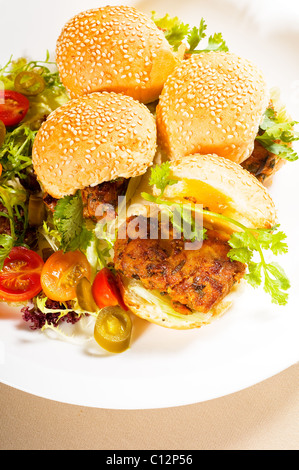 vier frische und köstliche Mini-Chicken Burger auf einem Teller, Nahaufnahme Stockfoto