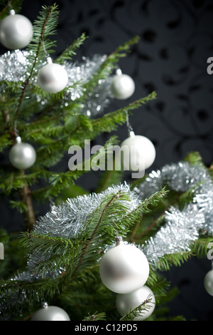 Silber schmückten Tanne Weihnachtsbaum mit Kugeln und Ketten, schwarze Tapete im Hintergrund Stockfoto