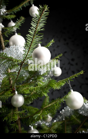 Silber schmückten Tanne Weihnachtsbaum mit Kugeln und Ketten, schwarze Tapete im Hintergrund Stockfoto
