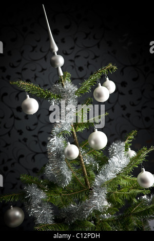 Silber schmückten Tanne Weihnachtsbaum mit Kugeln und Ketten, schwarze Tapete im Hintergrund Stockfoto