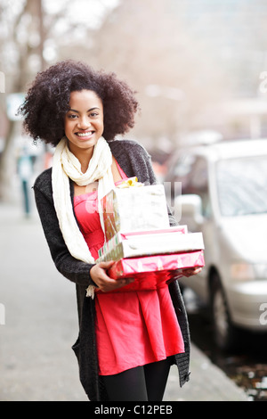 USA, Washington State, Seattle, junge fröhliche Frau, die Stapel von verpackte Geschenke Stockfoto