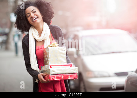 USA, Washington State, Seattle, junge fröhliche Frau, die Stapel von verpackte Geschenke Stockfoto