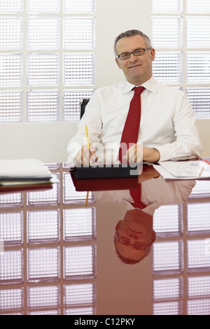 Porträt der kaukasischen Geschäftsmann stützte sich auf Stuhl mit Tablet-pc, Blick in die Kamera. Vertikale Form, Vorderansicht, Textfreiraum Stockfoto