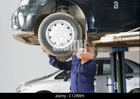 Kfz-Mechaniker arbeitet an einer Auto-Rad in einer garage Stockfoto