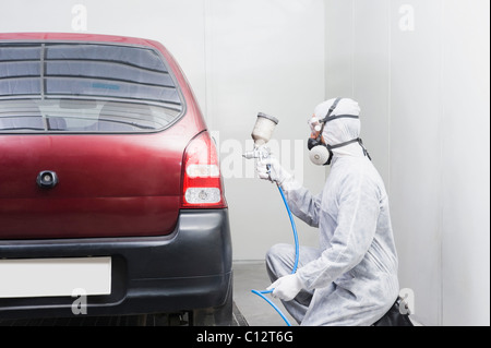 Kfz-Mechaniker malen ein Auto in einer garage Stockfoto