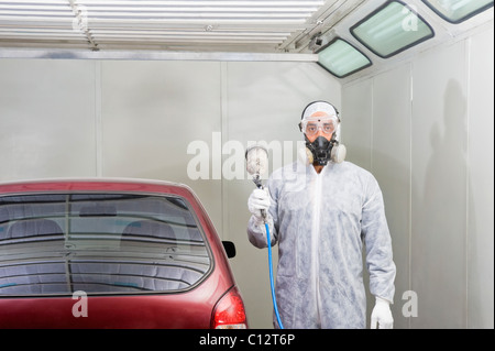 Kfz-Mechaniker hält eine Farbspritzpistole in einer garage Stockfoto