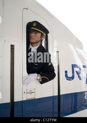 Shinkansen Bullet train Dirigent Kontrollen die Plattform wie der Zug aus Osaka Station gebunden für Tokio zieht. Stockfoto