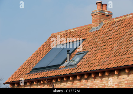 Integrierte thermische Sonnenkollektor auf dem Dach eines neu gebauten Hauses zur Warmwasseraufbereitung Stockfoto