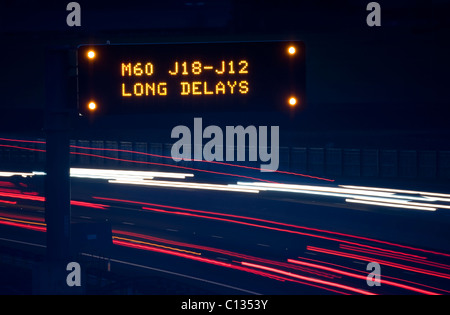 Scheinwerfer wegen des Verkehrs auf der Autobahn A1/M Weitergabe Gantry Warnsignal für Verzögerungen die M60 voraus in der Nacht in der Nähe von Leeds uk Stockfoto