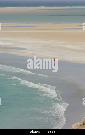 Fischer tragen sein Netz am Strand von Detwah Lagune Qulansiyah, Sokotra, Jemen Stockfoto