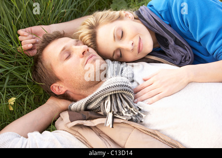 Junges Paar liegen zusammen auf dem Rasen Stockfoto
