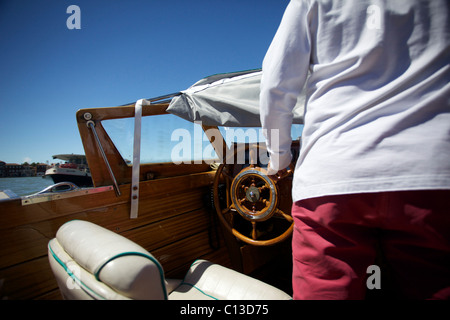 Die Hand des Piloten/Fahrer ein privates Wassertaxi steuert das Boot in Venedig, Italien Stockfoto