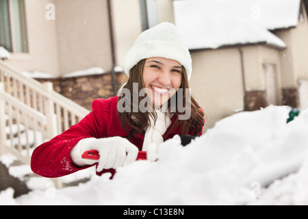 USA, Utah, Lehi, Porträt der jungen Frau Schnee vom Auto kratzen Stockfoto