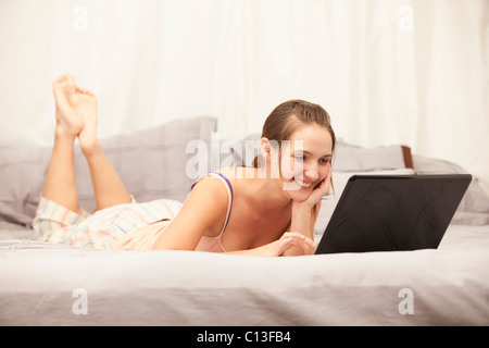 USA, Utah, Lehi, junge Frau mit Laptop am Bett Stockfoto