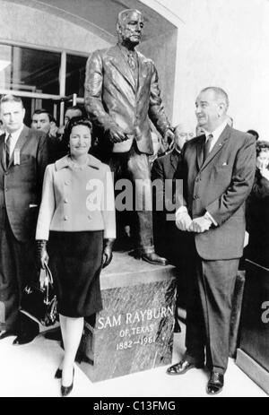 Vordergrund, von links: erste Lady Lady Bird Johnson und Präsident Lyndon B. Johnson bei der Einweihung einer Statue von der späten Sprecher des Hauses Sam Rayburn. Die Statue auf dem Rayburn House Office Building ist das Werk des Bildhauers Felix de Weldon. Washington, DC, 6. Januar 1965 Stockfoto