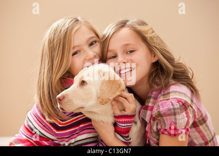 Porträt von zwei Mädchen (10-11), Lehi, Utah, USA umarmen Labrador Stockfoto