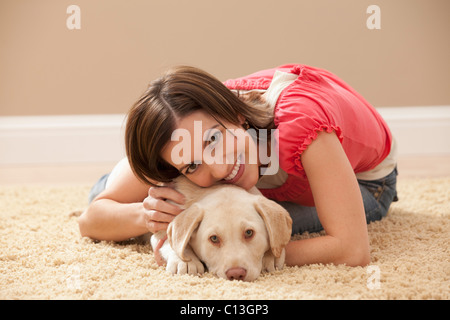 USA, Utah, Lehi, Portrait Frau umarmt Labrador auf Teppich Stockfoto