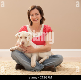 USA, Utah, Lehi, Portrait Frau umarmt Labrador auf Teppich Stockfoto