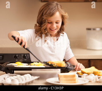 Mädchen (10-11) vorbereiten, Lehi, Utah, USA Frühstück in Küche Stockfoto