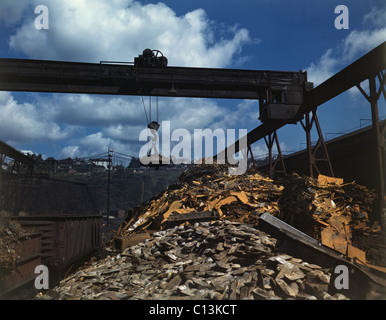 Recycling von Stahlschrott während des zweiten Weltkriegs an der Allegheny Ludlum Steel Corporation in Brackenridge, Pennsylvania. Ein obenliegender Magnet Einlagen den Schrott in einem Lader trägt es den offenen Ofen. 1941. Stockfoto