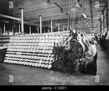 Frauen arbeiten bei Textilmaschinen, strahlend und Inspektion von Garn an die American Woolen Company, Boston. Die strahlende Prozess bereitet die Verwerfung, die längs Fasern aus einem gewebten Stoff. Ca. 1910. Stockfoto