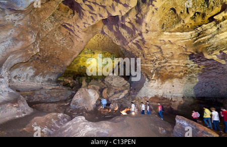 Höhle Touristen: Eine Gruppe von Touristen auf einer geführten Tour von der Loltu. Eine Gruppe von 8 Touristen folgt eine Führung durch eine massive Höhle Stockfoto
