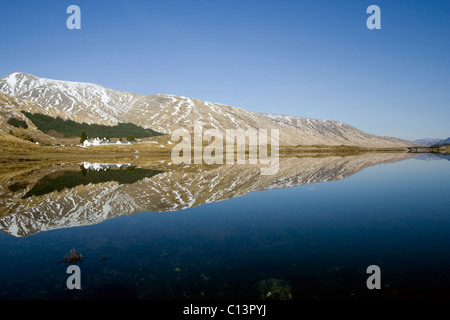 Die Cluanie Inn und die umliegenden Berge spiegeln sich in Loch Cluanie, Kintail Stockfoto