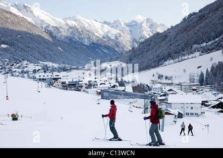 Skifahrer auf schneebedeckten Kinderskisten im Skigebiet Alpine mit Bergen jenseits. St. Anton am Arlberg, Tyrol, Österreich Stockfoto