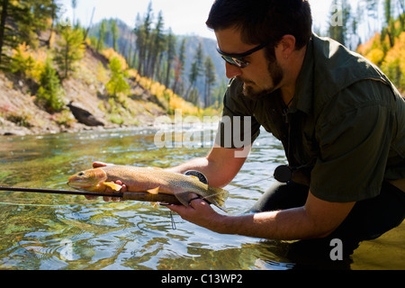 USA, Montana, Mann halten Fisch in North Fork des Blackfoot River Stockfoto