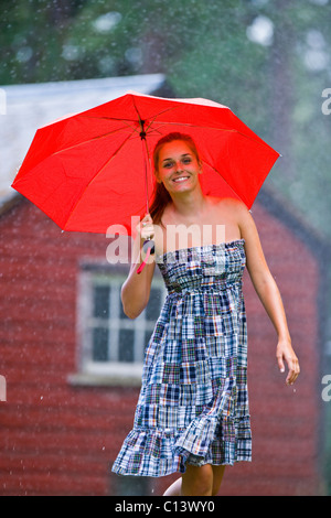 USA, Montana, Felchen, Porträt der jungen Frau mit Regenschirm im Regen Stockfoto