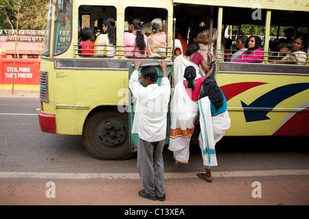 Frauen gehen Sie an Bord eines Busses in einem Dorf südlich von Kochi, Kerala, Indien Stockfoto