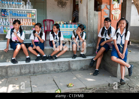 Balinese Mittelschule Mädchen zu stoppen, für einen Snack und ein Getränk auf dem Heimweg von der Schule Stockfoto