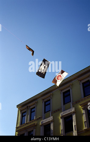 Flaggen der Fußballverein FC Sankt Pauli aufgehängt an einem Seil zwischen zwei Mehrfamilienhäuser in Sankt Pauli Bezirk von Hamburg. Stockfoto