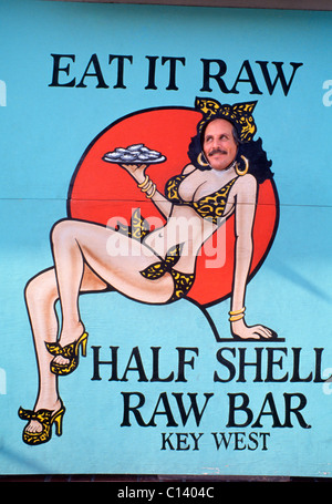 Ein mustached Mann posiert im Foto Ausschnitt Zeichen des Bikini bekleideten Kellnerin an der Hälfte Shell Raw Bar, ein Meeresfrüchte-Restaurant in Key West, Florida, USA. Stockfoto