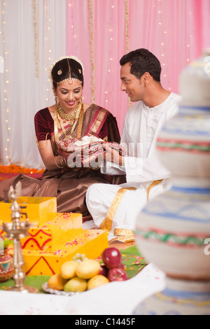 Bräutigam der Braut bei der Süd-indischen Hochzeit Zeremonie einen Sari verleihen Stockfoto