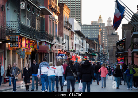 Menschen, die Kreuzfahrten in Bars und Diskotheken auf der Bourbon Street in der Nacht in New Orleans Stockfoto