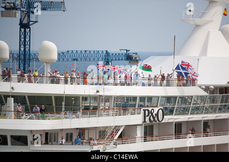 Passagiere an Bord der "Artemis" wehende Fahnen als P & O Segel Schiff im Hafen von Barcelona verabschiedet. Spanien Stockfoto