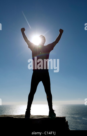 Silhouette eines männlichen Athleten am Meer bis in den Himmel zu erreichen Stockfoto