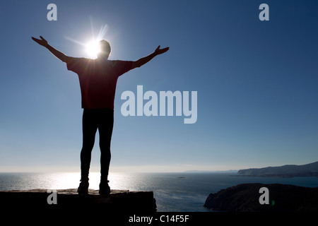 Silhouette eines männlichen Athleten am Meer bis in den Himmel zu erreichen Stockfoto