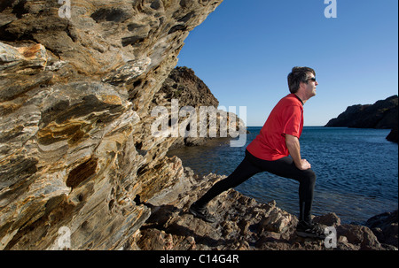 Mann, erstreckt sich auf einer felsigen Küste in Spanien Stockfoto