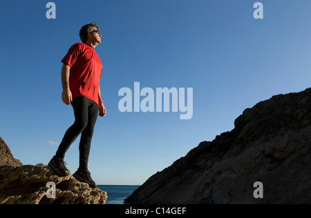 Mann steht auf einer felsigen Küste in Spanien Stockfoto