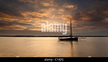 Boot mit Sonnenuntergang auf dem Wasser Stockfoto