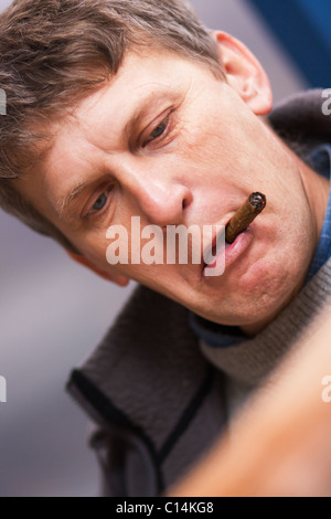Reifer Mann mit Zigarre enttäuscht beim Zeitung lesen Stockfoto