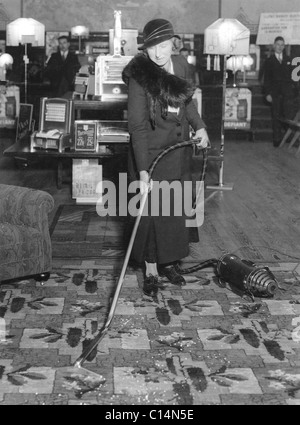 Frau, die im Ausstellungsraum des Möbelgeschäfts in Großbritannien (UK circa) mit einem Staubsauger demonstriert. 1930-1933 Stockfoto