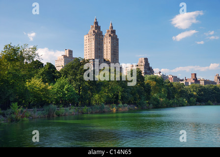 New York City Central Park städtischen Manhattan Skyline mit Wolkenkratzern und Bäume See Spiegelung mit blauen Himmel und weiße Wolke. Stockfoto