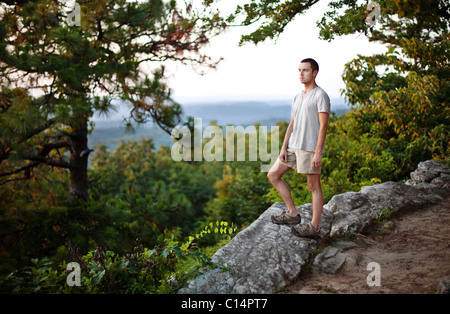 Junger Mann hält Ausschau auf einem Aussichtspunkt beim Wandern im Oak Mountain State Park in Birmingham, Alabama. Stockfoto