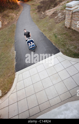 Overhead Schuss von einem Mann läuft auf ein Greenway mit seinen zwei Söhnen in einem Kinderwagen. Stockfoto
