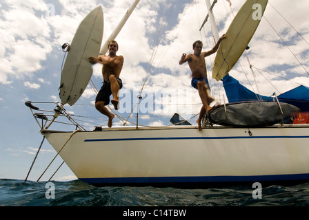 Zwei Jungs aus ihrer Position heraus für Boot springen Surfen in Costa Rica Stockfoto